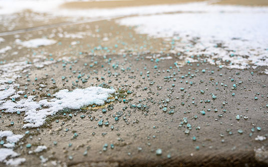 Blauer Salzstein auf schwarzem Asphaltweg Blauer Salzstein auf schwarzem Asphaltweg