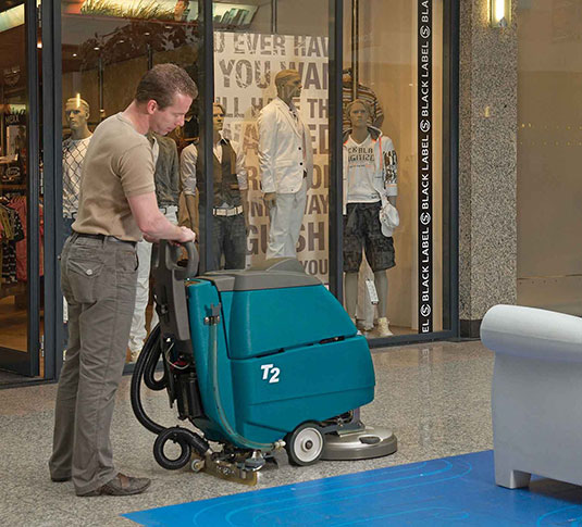cleaning crew using Tennant walk-behind floor scrubber in main area of retail store cleaning crew using Tennant walk-behind floor scrubber in main area of retail store