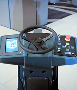 Una restregadora de pisos de Tennant Company limpiando en piloto automático Una restregadora de pisos de Tennant Company limpiando en piloto automático